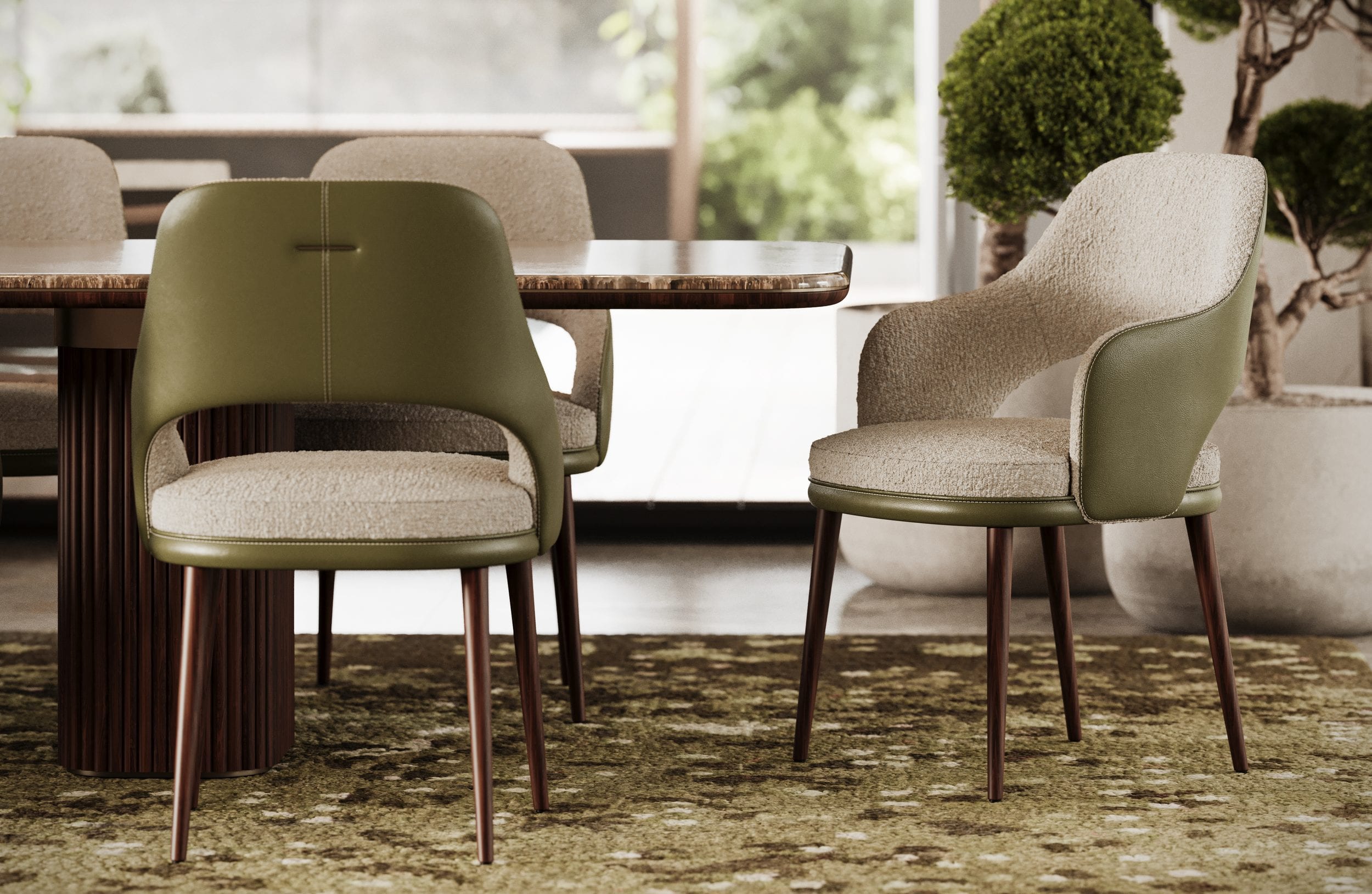 Two chairs drawn up to a marble table on a mossy green rug, one in olive leather, one in cream bouclé