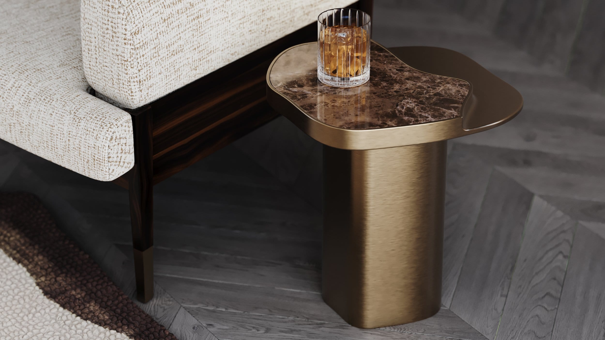 Brushed brass and brown marble side table beside a bouclé sofa, material and finish detail
